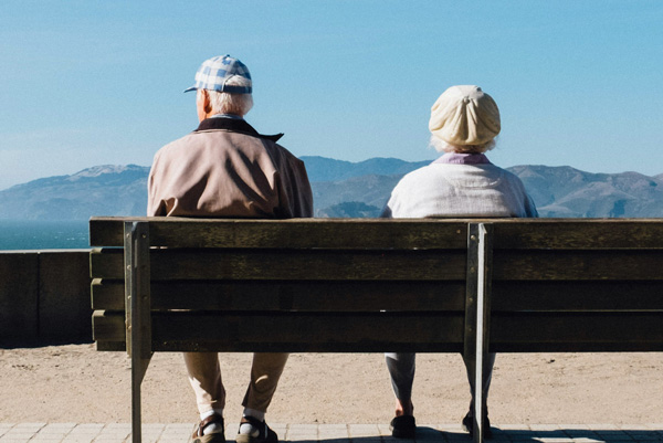 Couple sitting on a bench together. Matt Bennett, Unsplash.